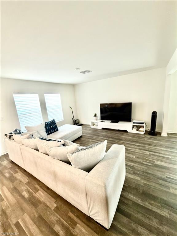 Open-concept living area featuring wood-finish flooring, white baseboards, and white walls