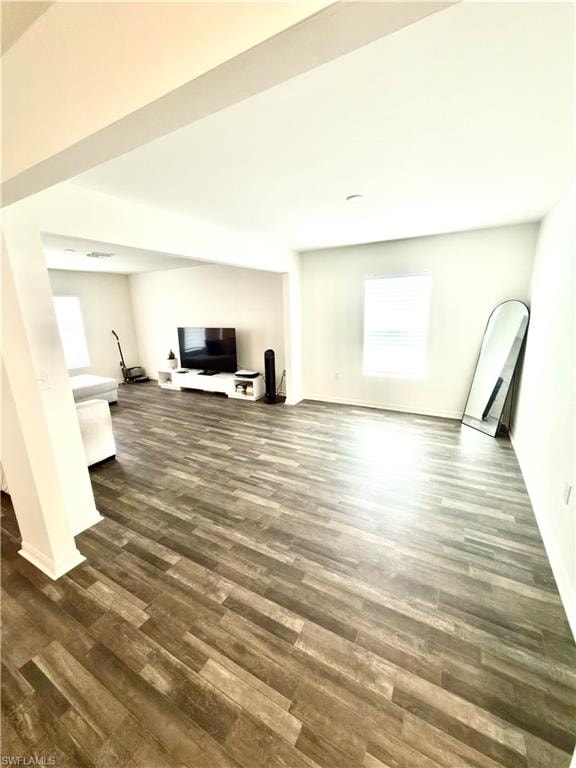 Spacious interior featuring wood-finish flooring, white baseboards, and neutral wall paint