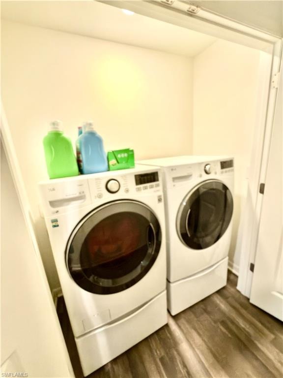 Dedicated laundry space featuring a white front-loading washer and dryer, wood-finish flooring, and recessed ceiling lighting