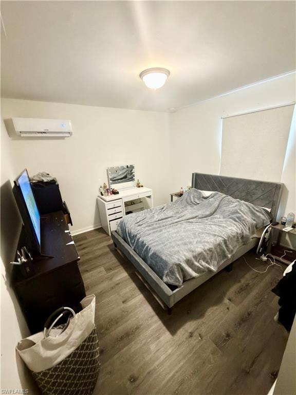 Neutral tone walls featuring a wall-mounted mini-split system and wood-finish flooring