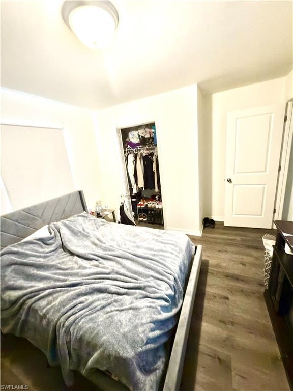Spacious living area featuring wood-finish flooring, white walls, and abundant natural light from two large windows