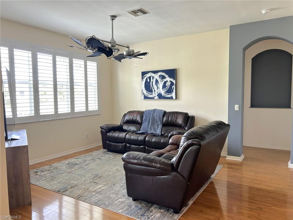 Living room with light wood finished floors and arched walkways