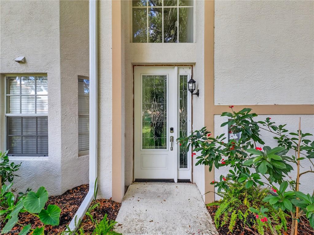 Doorway to property featuring stucco siding