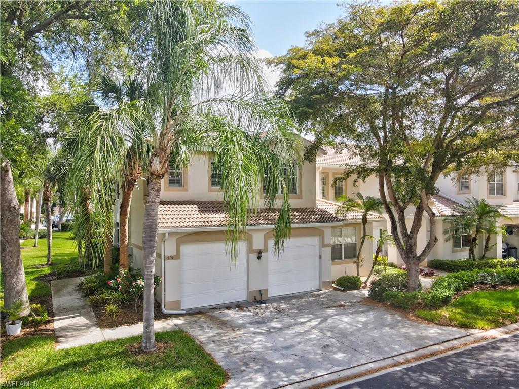 Mediterranean / spanish home with concrete driveway, an attached garage, stucco siding, and a tiled roof