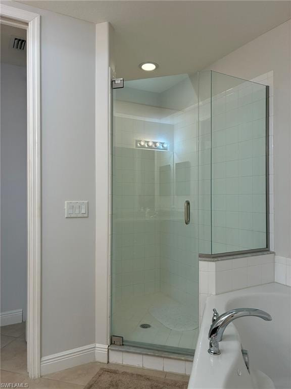 Glass-enclosed shower featuring white subway tile, recessed lighting, and a chrome shower handle