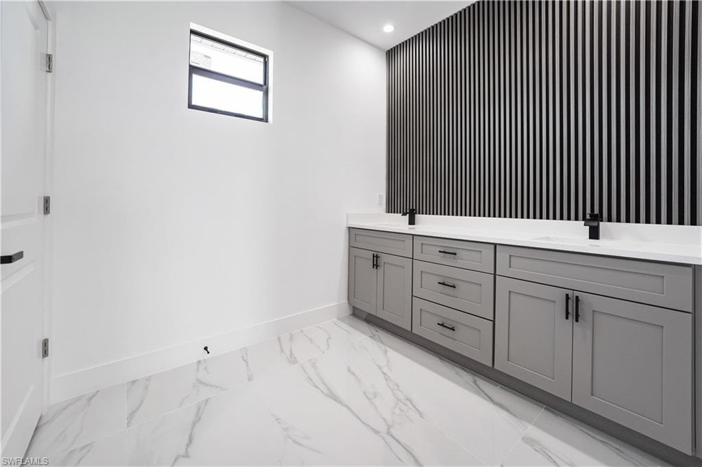 Dual vanity with gray cabinetry, white countertops, and matte black fixtures