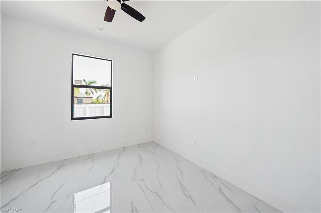Room featuring a black framed window, white walls, and marble-look tile flooring