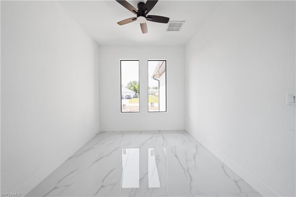 Room featuring white walls and large-format porcelain tile flooring