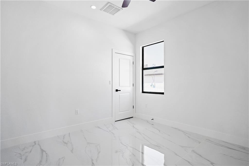 Bright room featuring large format tile flooring, a contemporary ceiling fan, and a black-framed window