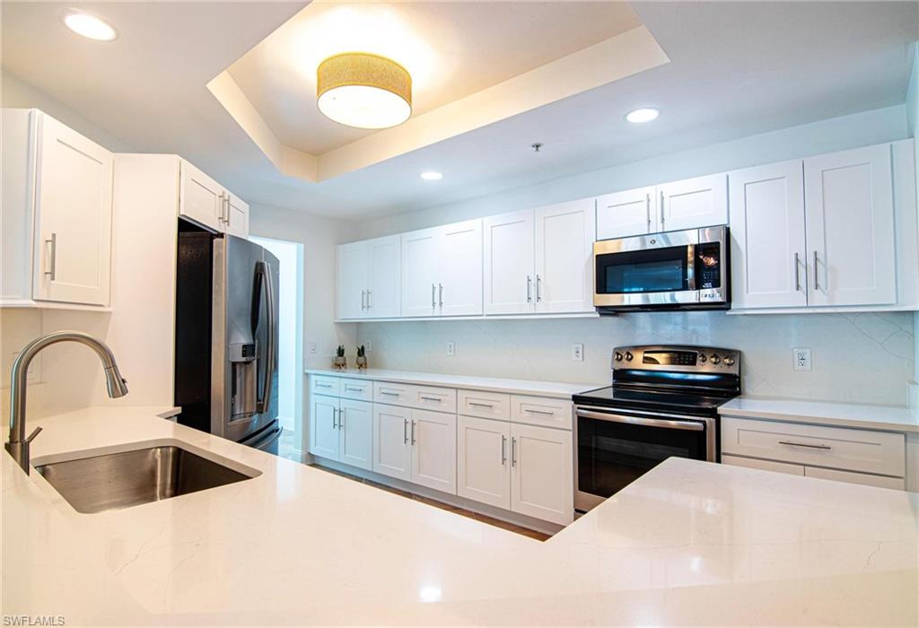 HUGE KITCHEN is equipped with QUARTZ countertops and backsplash, BRAND NEW CUSTOM-MADE WHITE SHAKERS CABINETS, newer STAINLESS-STEEL GE PROFILE APPLIANCES & breakfast or cocktail SITTINGBAR AREA.