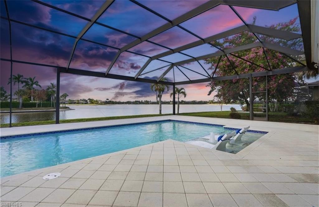 Screened lanai featuring a rectangular swimming pool and integrated spa