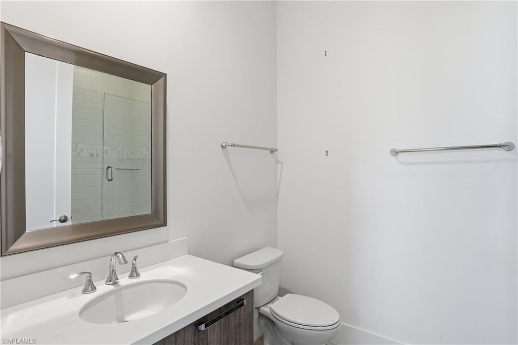 Bathroom vanity featuring an integrated oval sink, chrome faucet, and wood-finish cabinetry