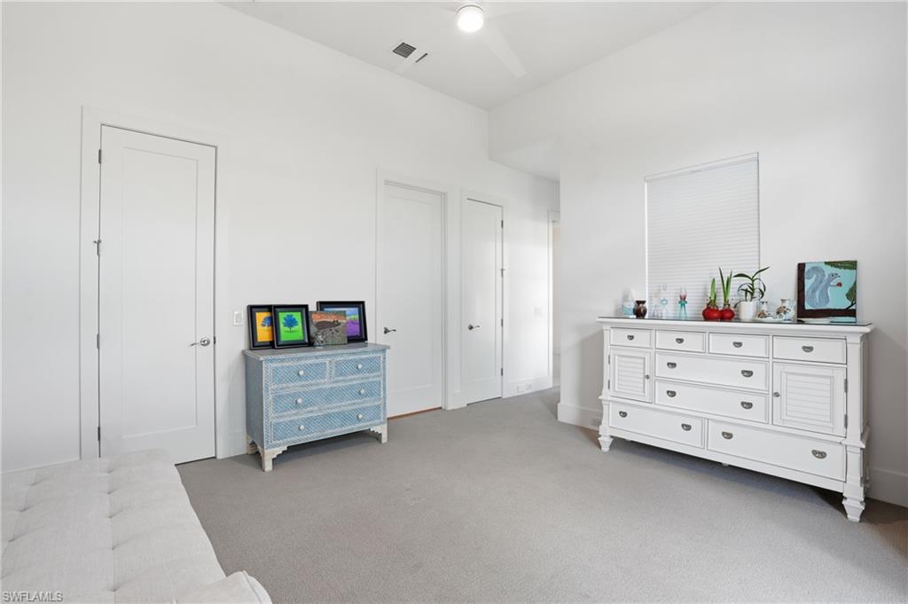 Spacious room featuring light-colored carpeting and white walls