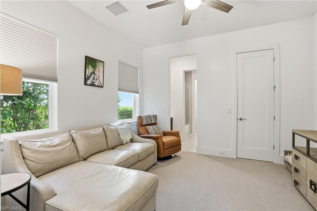 Carpeted living space featuring recessed lighting, a ceiling fan, and two windows with blinds
