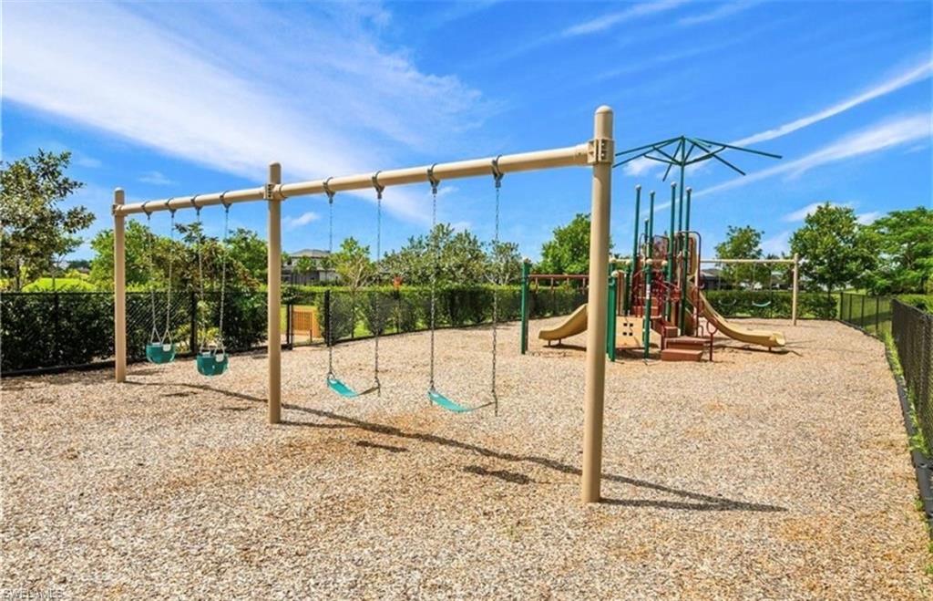 Community playground featuring a swing set, multi-level play structure, and slides