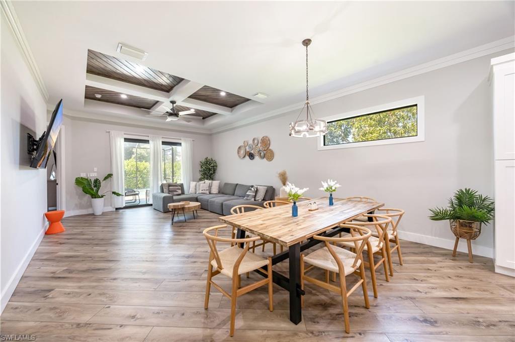 Open-concept interior featuring wood-finish flooring, a coffered ceiling with wood accents, and recessed lighting