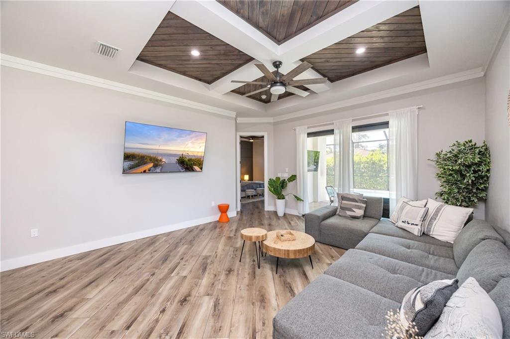 Living area featuring a coffered ceiling with wood-finish panels and a ceiling fan