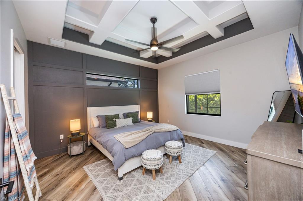 Spacious room featuring a tiered ceiling with recessed lighting and a ceiling fan