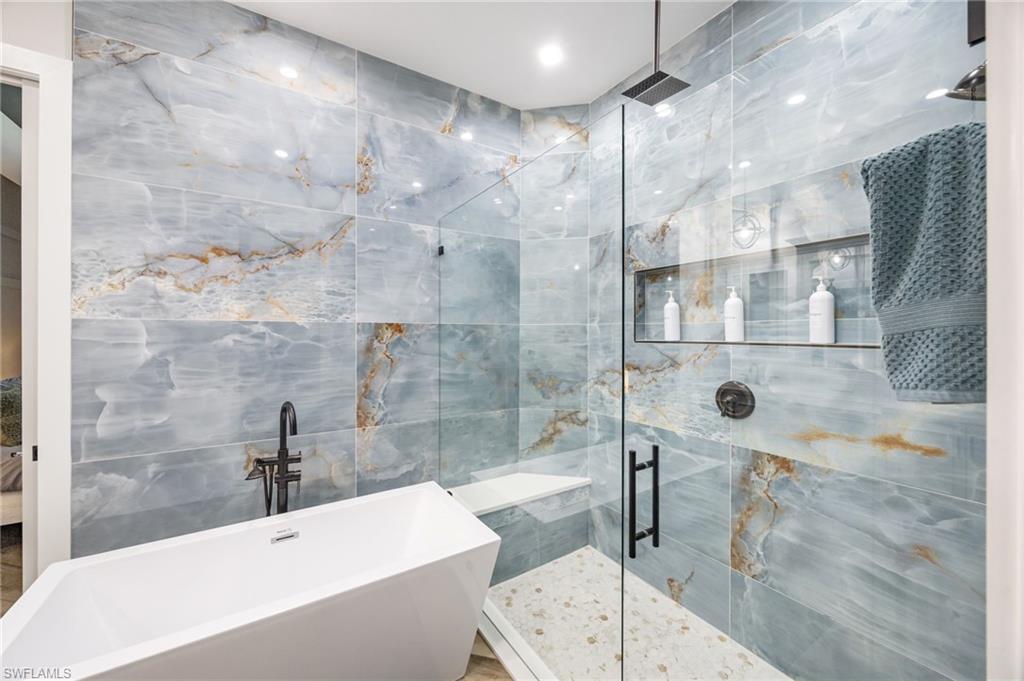 Freestanding soaking tub with a wall-mounted matte black faucet