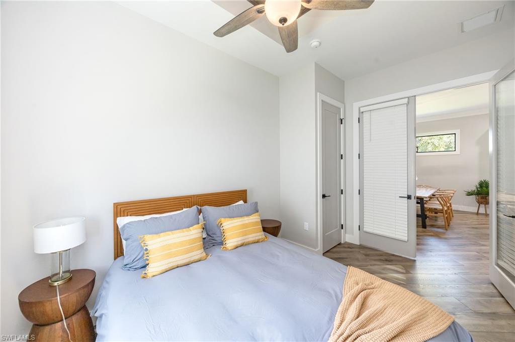 Bedroom featuring wood-finish flooring, a ceiling fan with integrated lighting, and a neutral color palette