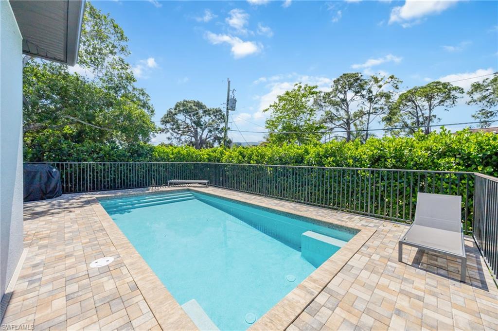 Rectangular swimming pool surrounded by paver patio