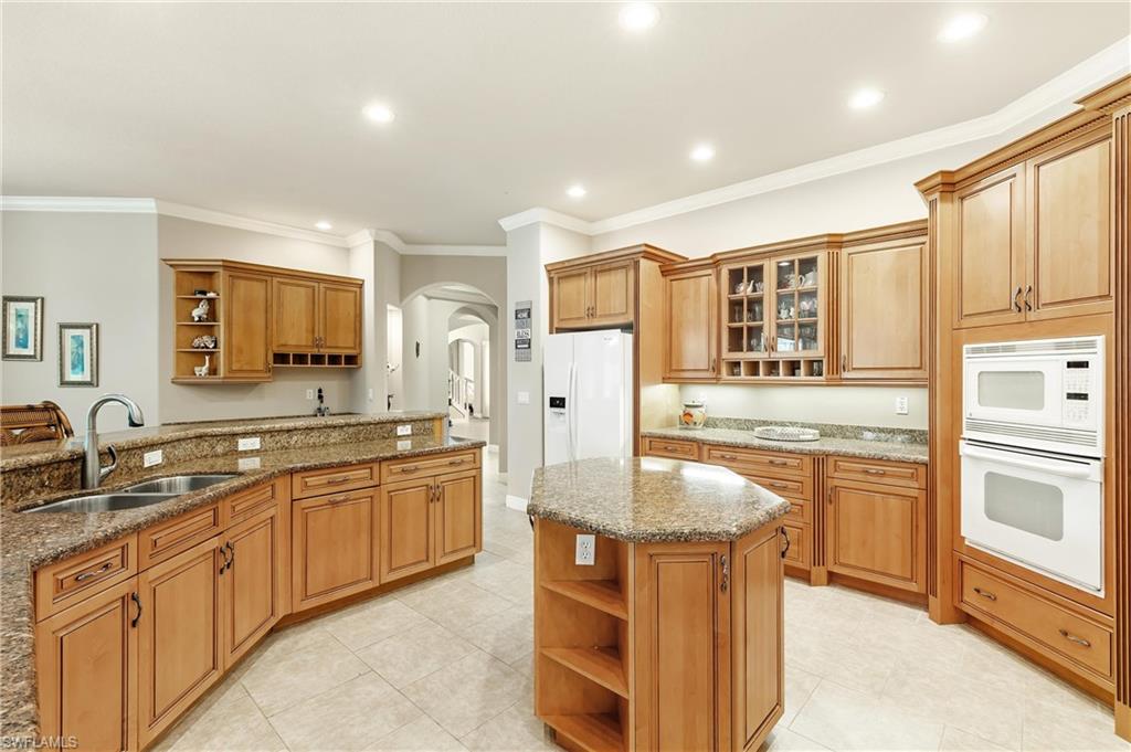 Spacious kitchen featuring extensive wood cabinetry, granite countertops, and tile flooring