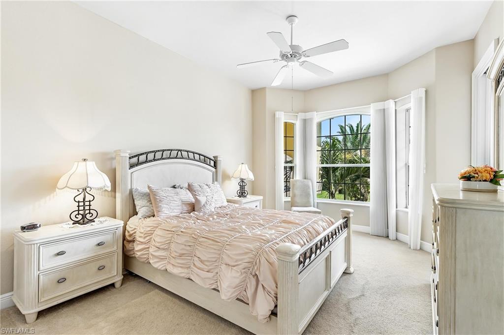 Upstairs bedroom with en-suite bathroom.  Carpeted room featuring a bay window, ceiling fan, and light-toned walls