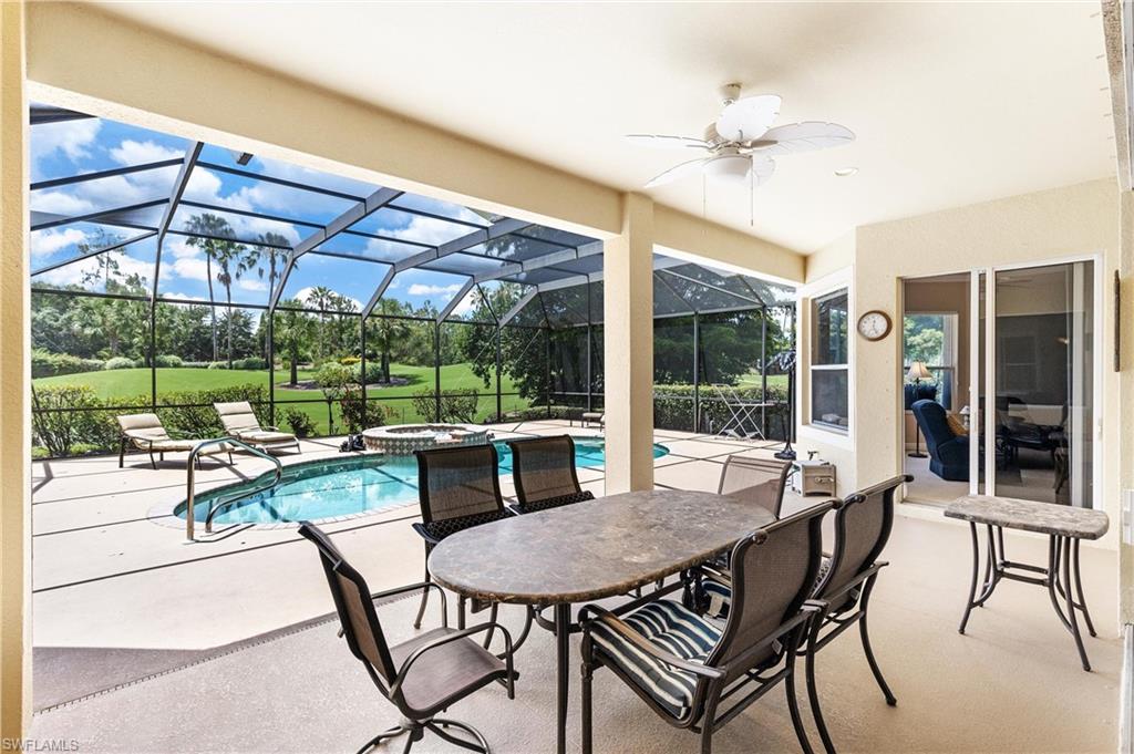 Screened lanai featuring a built-in swimming pool, integrated spa, and an expansive paved deck