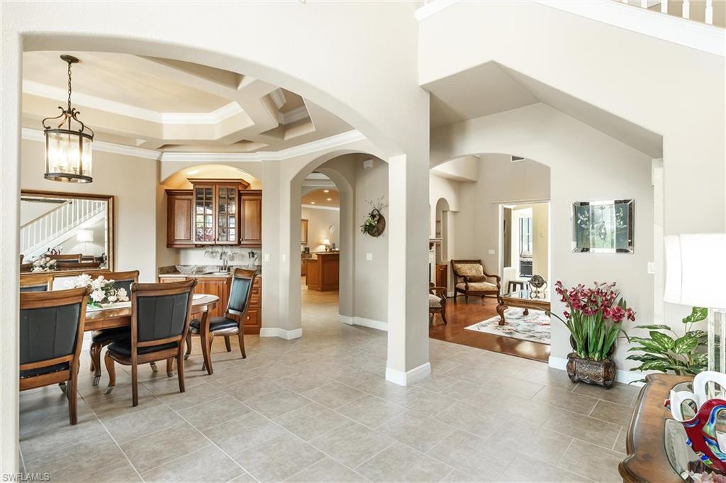 Spacious interior featuring a dining area with tray ceiling, built-in cabinetry, and tile flooring