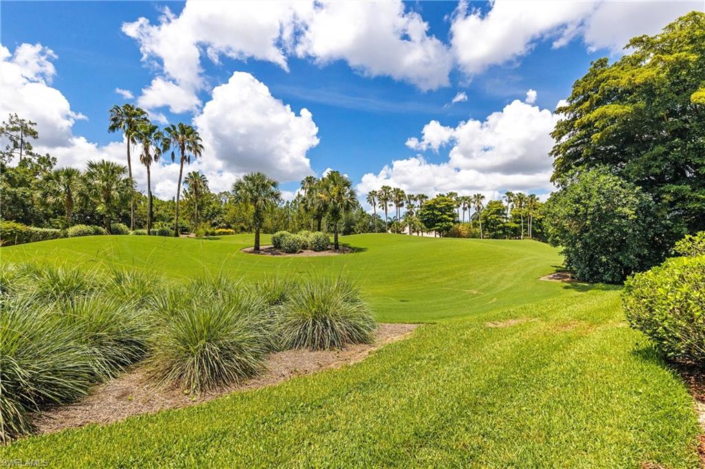 Expansive green space featuring manicured lawns and mature tropical landscaping