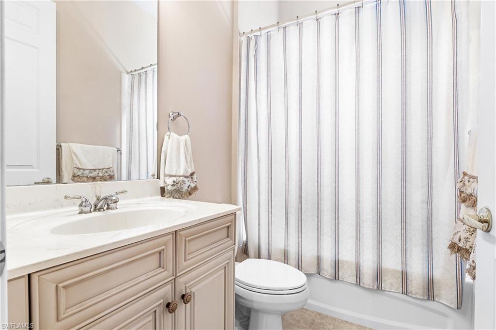 Bathroom featuring a vanity with an integrated sink, polished chrome faucet, and a large wall-mounted mirror