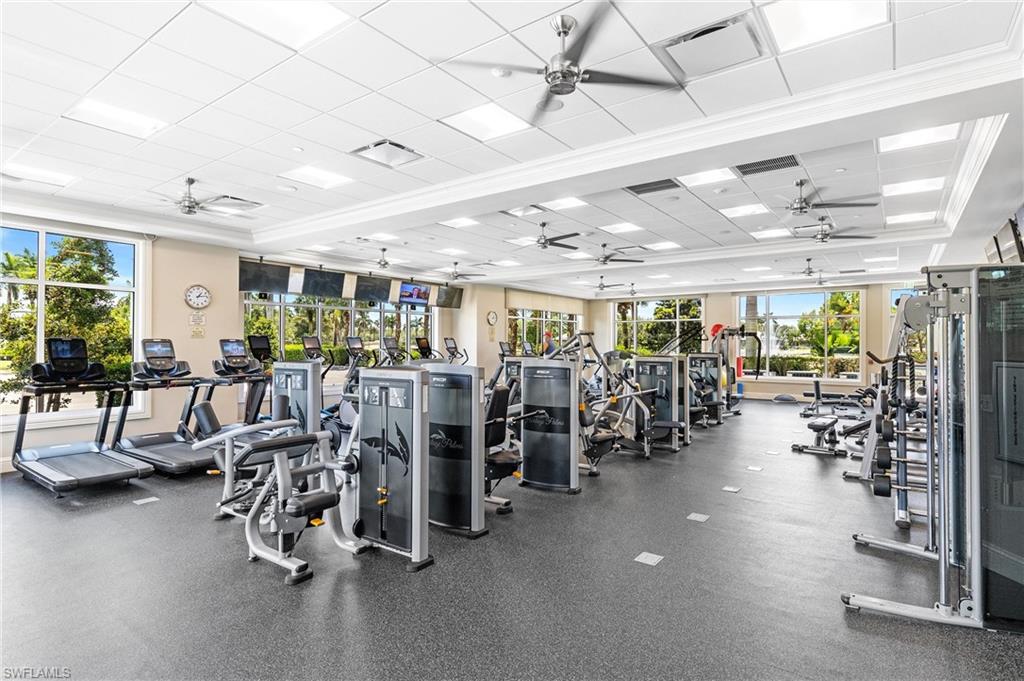 Community Fitness Center spacious fitness center featuring expansive windows, a textured flooring surface, multiple ceiling fans, recessed lighting, and a variety of exercise equipment