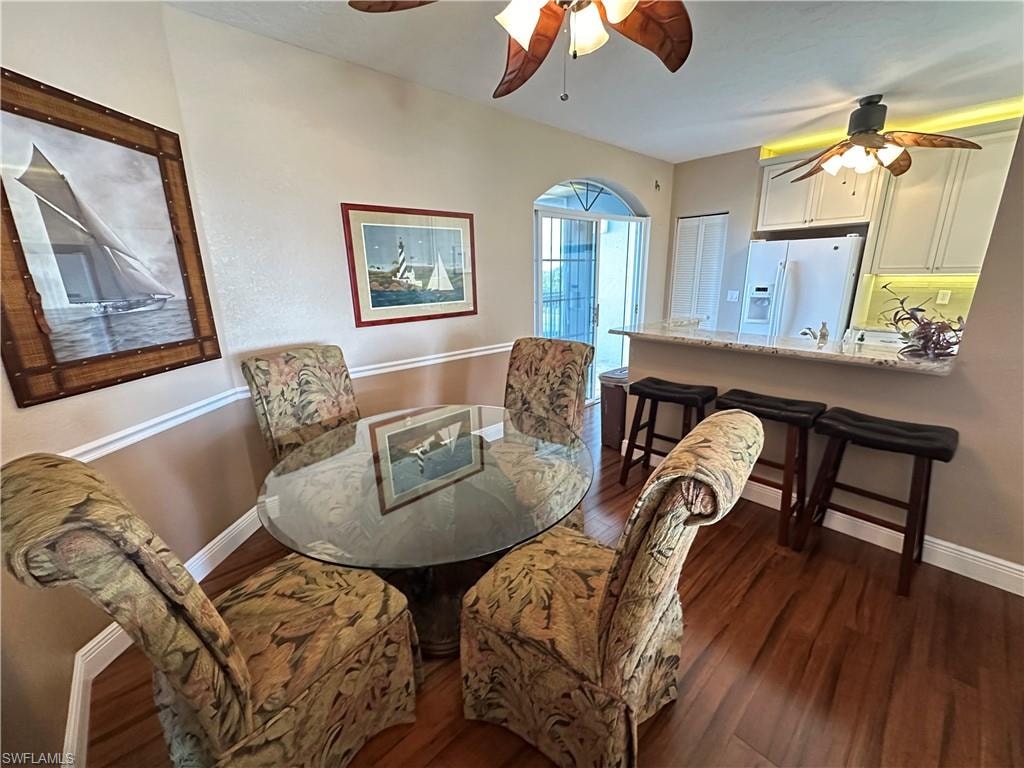Seating For 7 at Dining area and kitchen areas.  Featuring wood-finish flooring, a chair rail, and an arched doorway