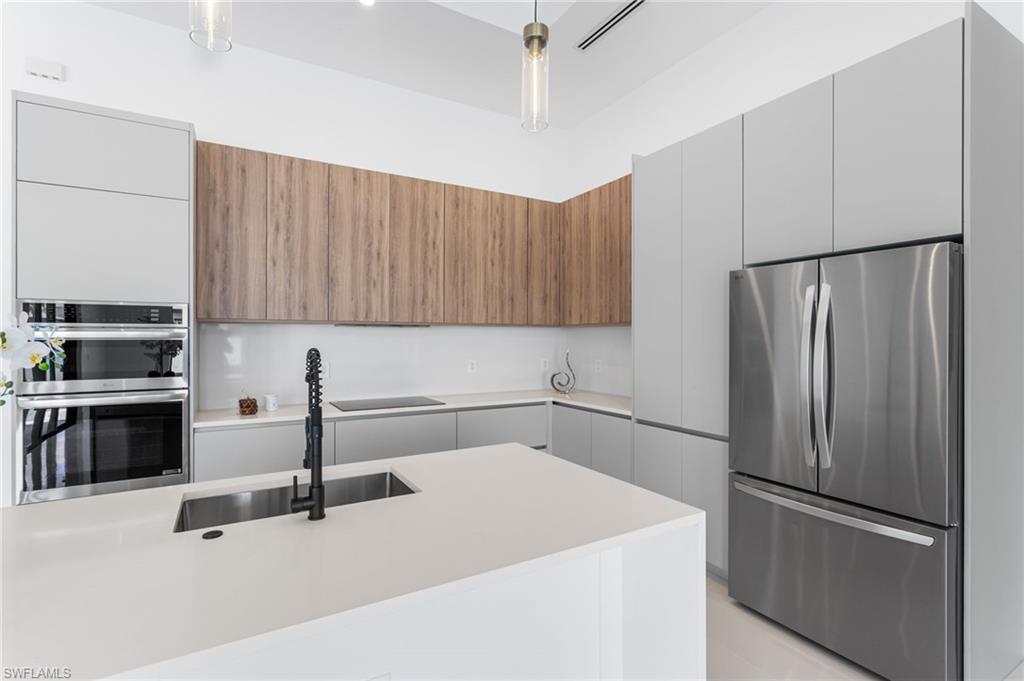 CUSTOM CABINETRY, QUARTZ COUNTERTOPS,and A LARGE SINK complete with a SLEEKMATTE BLACK FAUCET with pull-down springspout
