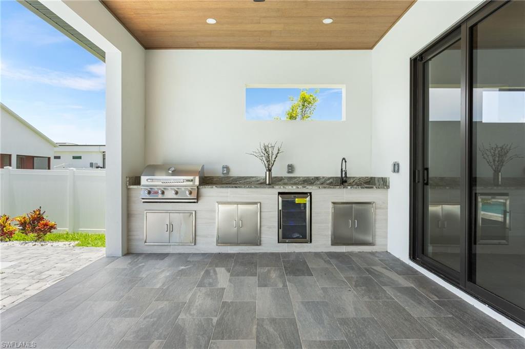 The OUTDOOR KITCHEN is READY forENTERTAINING with a BUILT-IN BBQ GRILL,MINI FRIDGE, COMMERCIAL GRADE SINK, andplenty of counter and cabinet space for all yourCULINARY NEEDS
