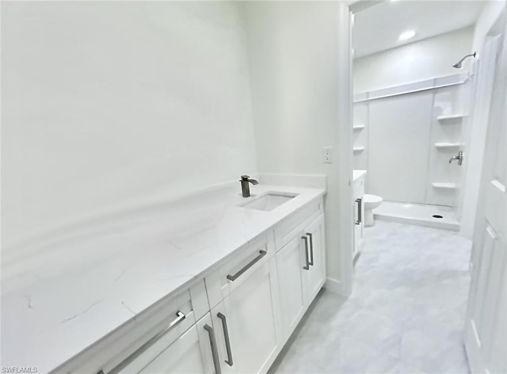 Bathroom with dual vanities, dual sinks, and shower