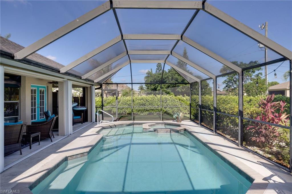 Screened enclosure encompassing a swimming pool and spa