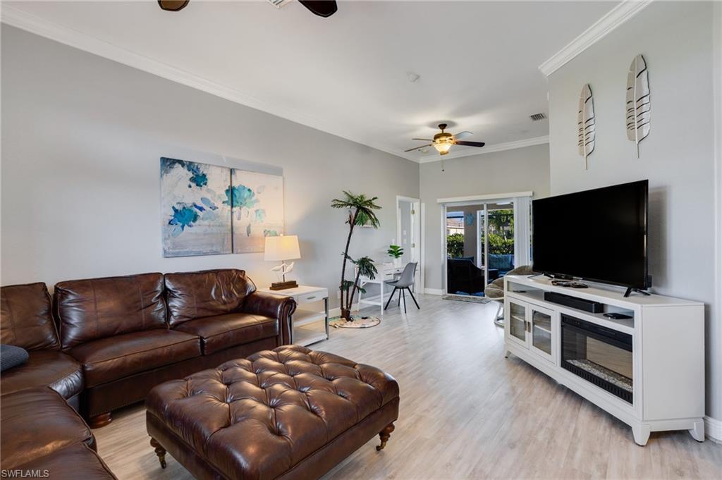 Spacious living area featuring wood-finish flooring, crown molding, and recessed lighting