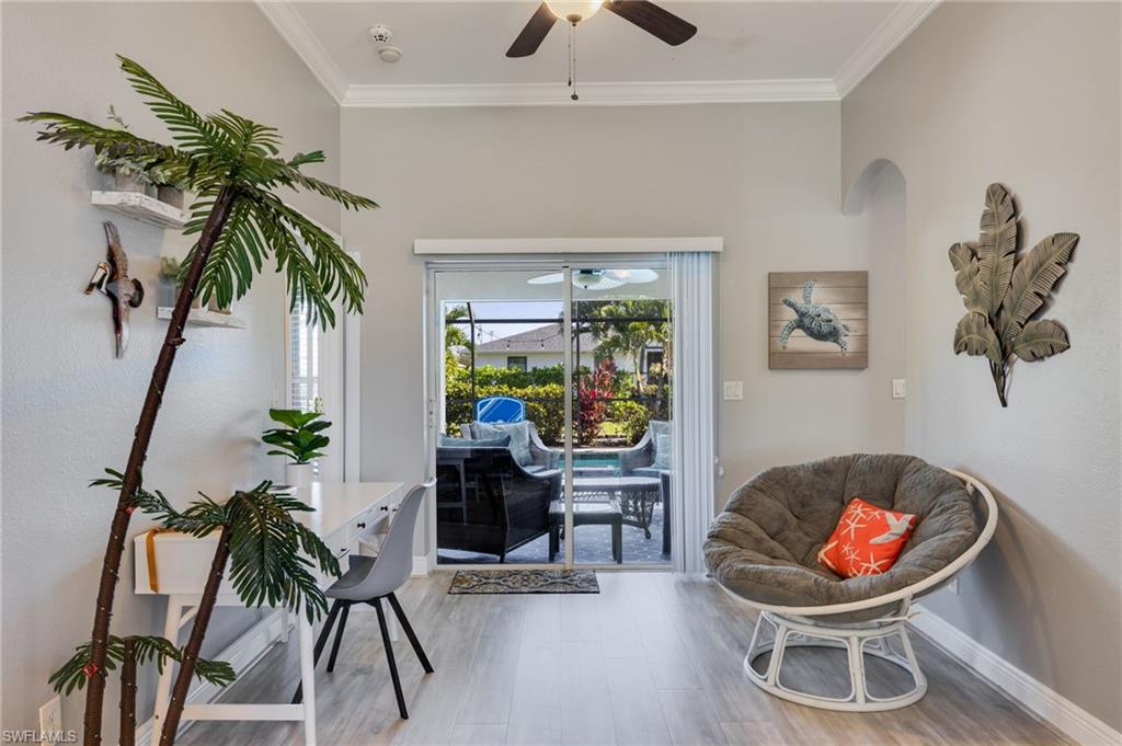 Sliding glass doors opening to the outdoor space, vaulted ceilings with crown molding, wood-finish flooring, recessed lighting, and an arched entryway