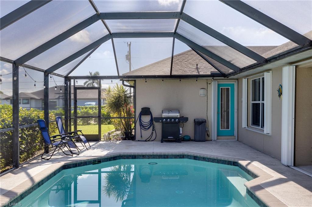 Screened lanai featuring a swimming pool, concrete decking, and a turquoise entry door