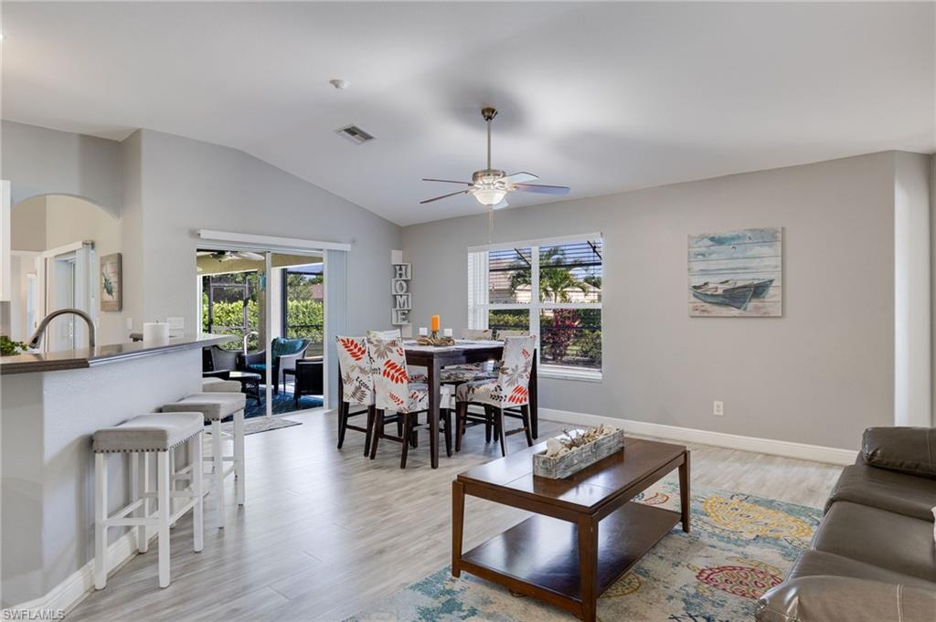 Vaulted ceilings enhance this open-concept living space, featuring light wood-finish flooring throughout
