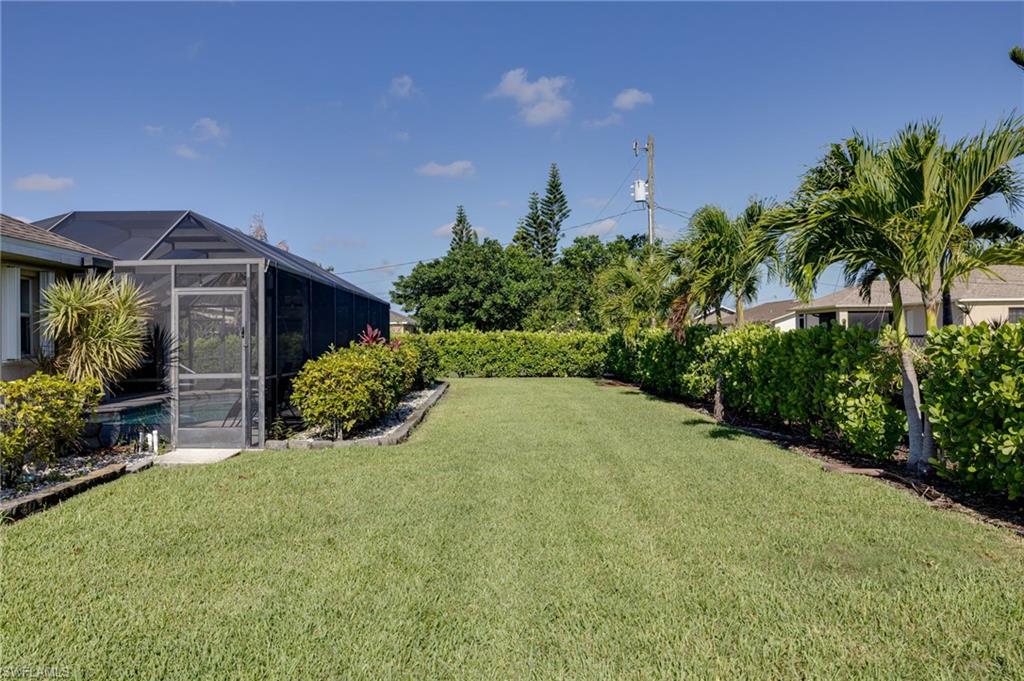 Expansive grassy yard area with mature shrubbery
