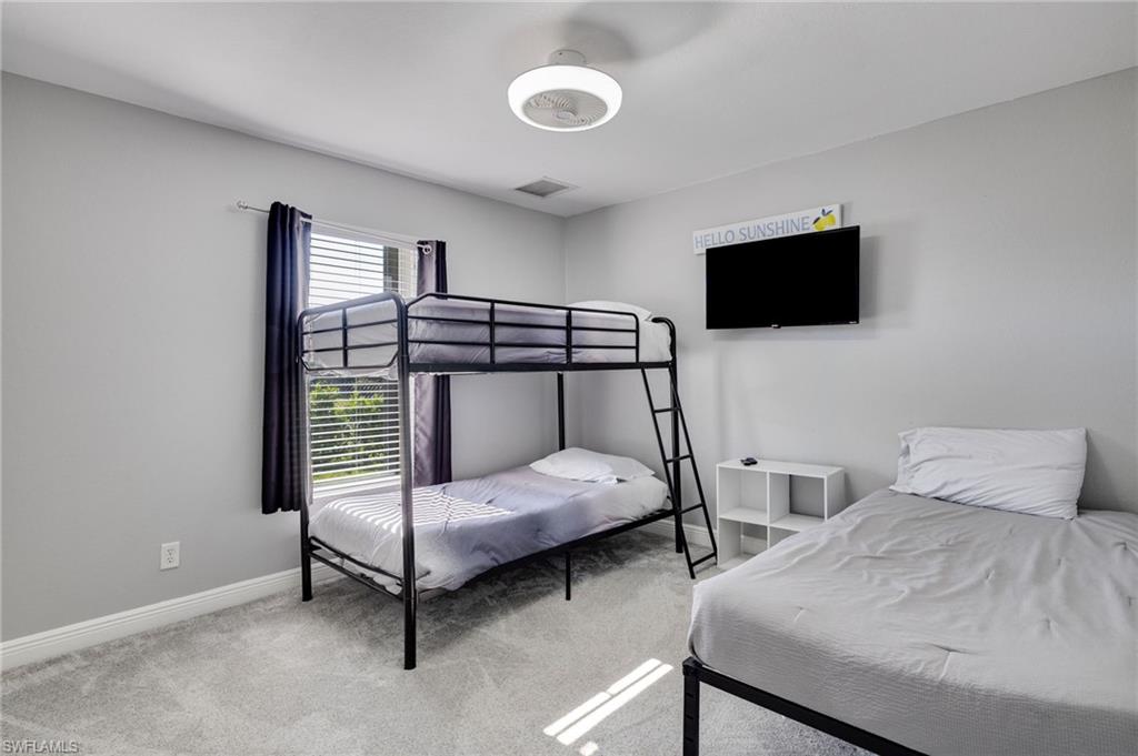 Carpeted room featuring a window with blinds and drapes, a flush-mount ceiling light fixture, and light gray wall paint