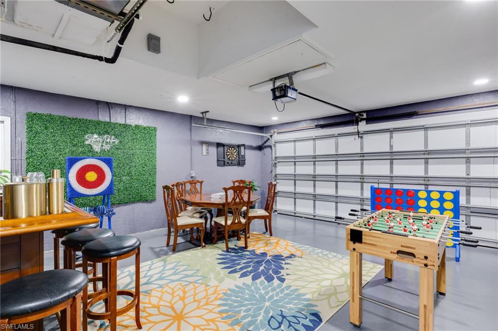Finished garage space featuring a large floral area rug and recessed lighting