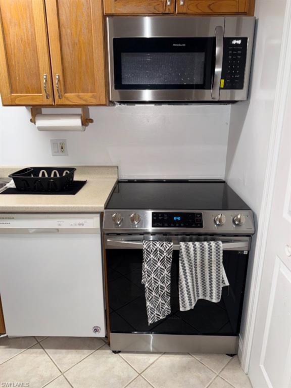 Stainless steel range with a smooth-top cook surface and coordinating over-range microwave
