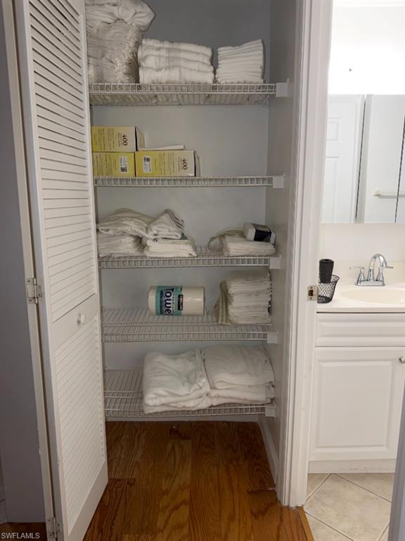 Built-in closet featuring louvered bi-fold doors, white wire shelving, and wood-finish flooring