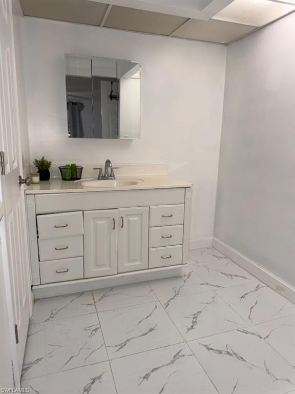 Bathroom vanity featuring a white cabinet with multiple drawers and a central double-door storage