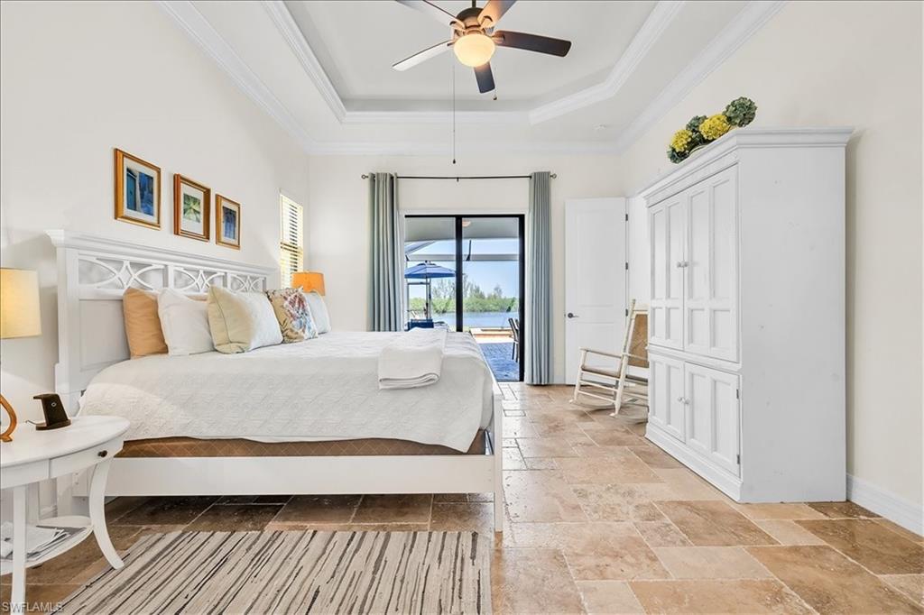 Room featuring a tray ceiling, recessed lighting, ceiling fan, and tile flooring