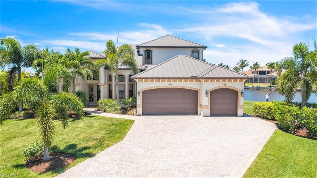 Two-story residence featuring a tile roof, stucco exterior, and a paver driveway