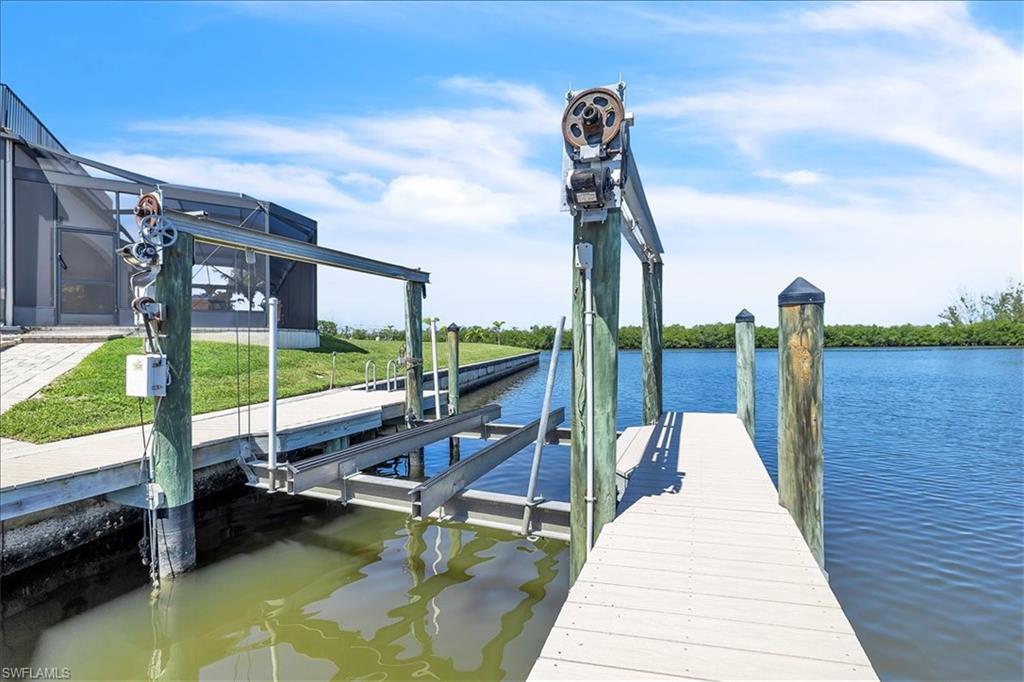 Waterfront property featuring a private boat lift, a composite dock, and direct canal access